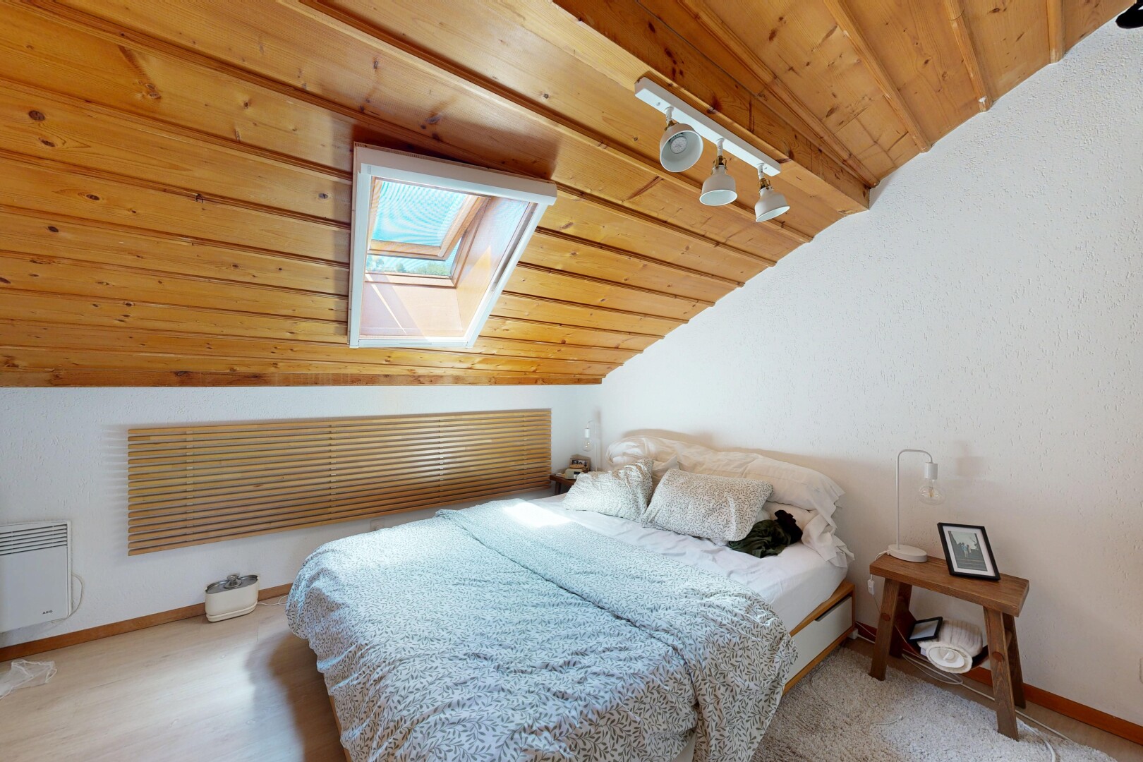 room with wood ceiling, lofted ceiling with skylight, and heating unit