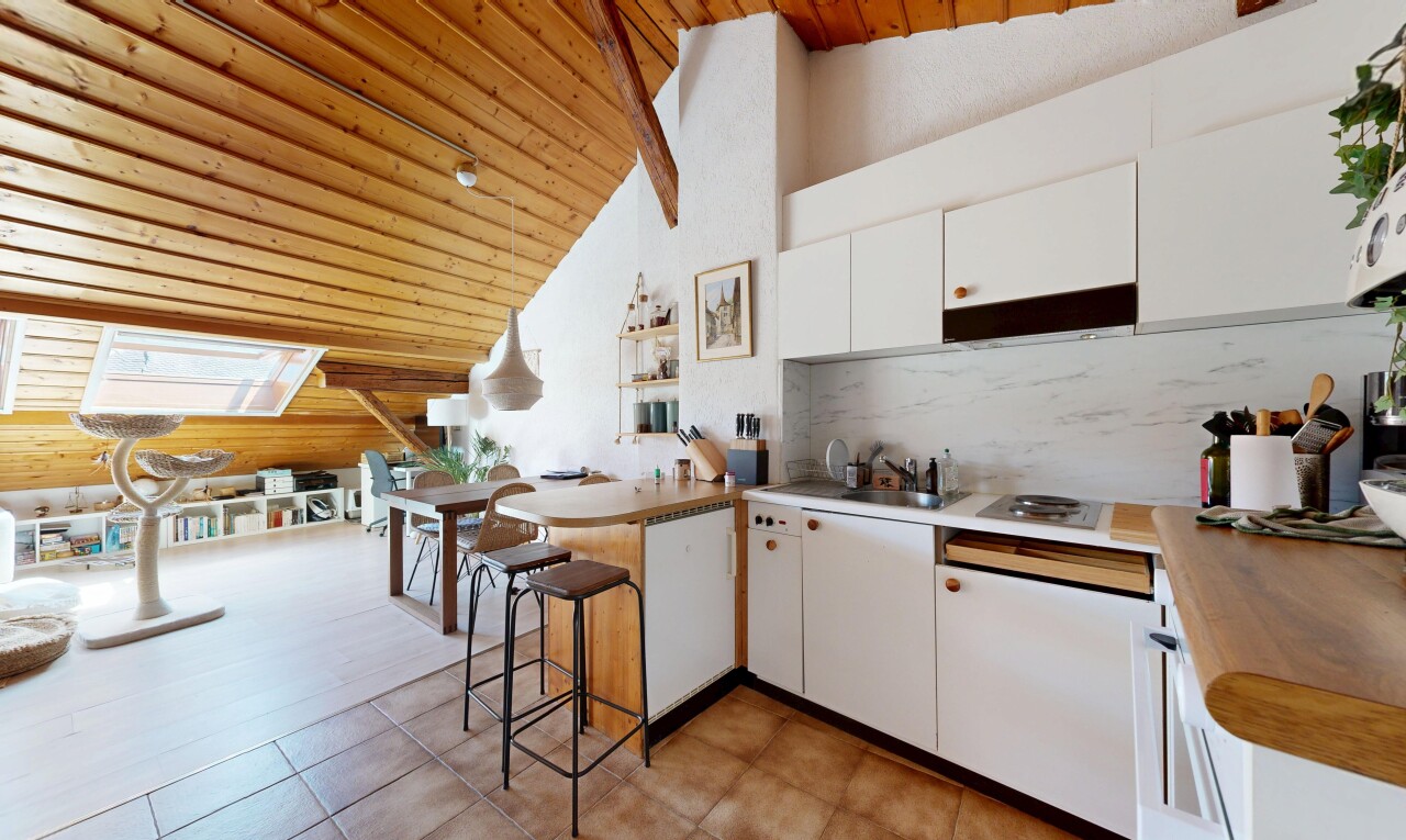 kitchen featuring a vaulted wood ceiling, a peninsula, white cabinets, a kitchen breakfast bar, and wooden counters
