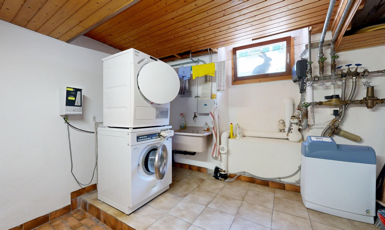 laundry area featuring stacked washer / drying machine and wood ceiling