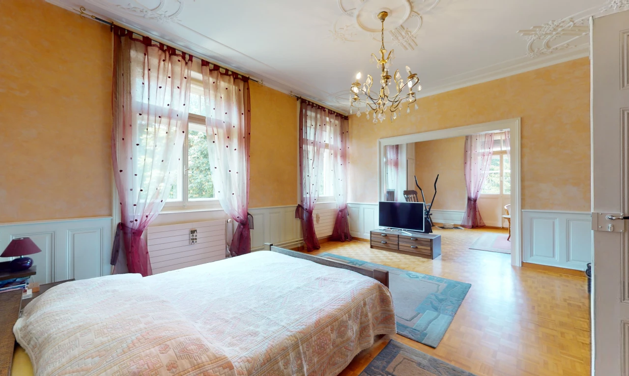 bedroom with hardwood floors, multiple windows, a chandelier, and TV