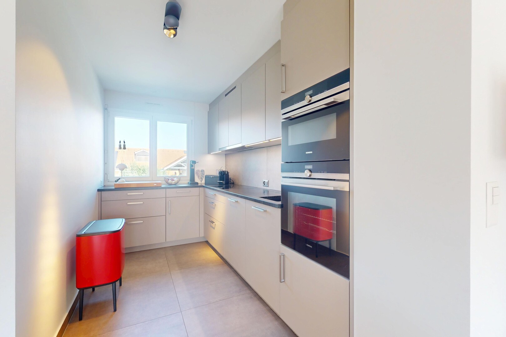 kitchen with double oven, white cabinets, and light tile patterned floors