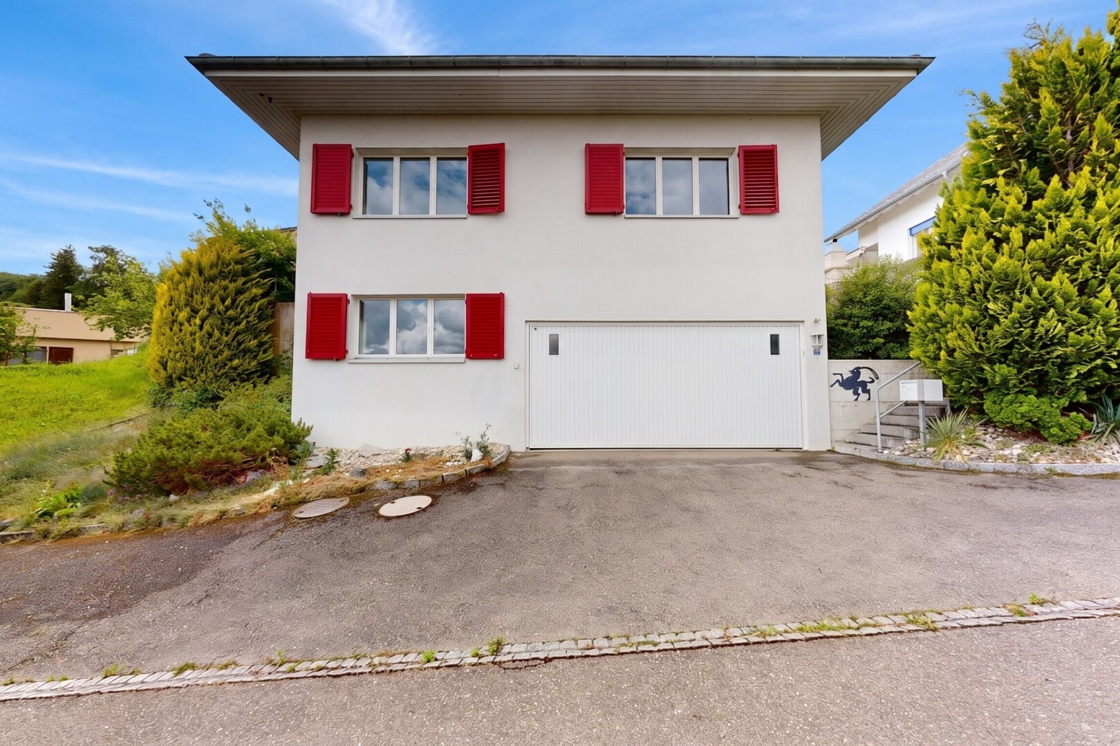 außenansicht mit day time, stuckverkleidung, property visible, auffahrt, und eingebaute garage