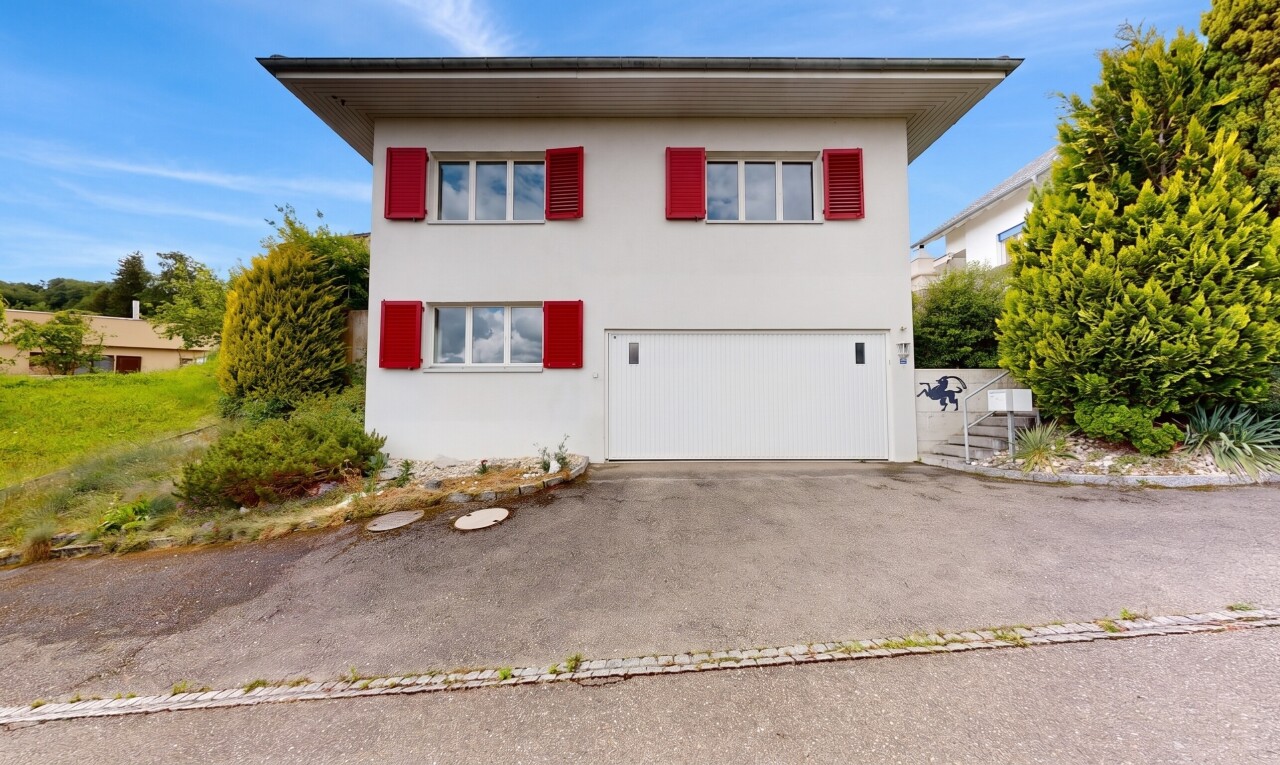 außenansicht mit day time, stuckverkleidung, property visible, auffahrt, und eingebaute garage