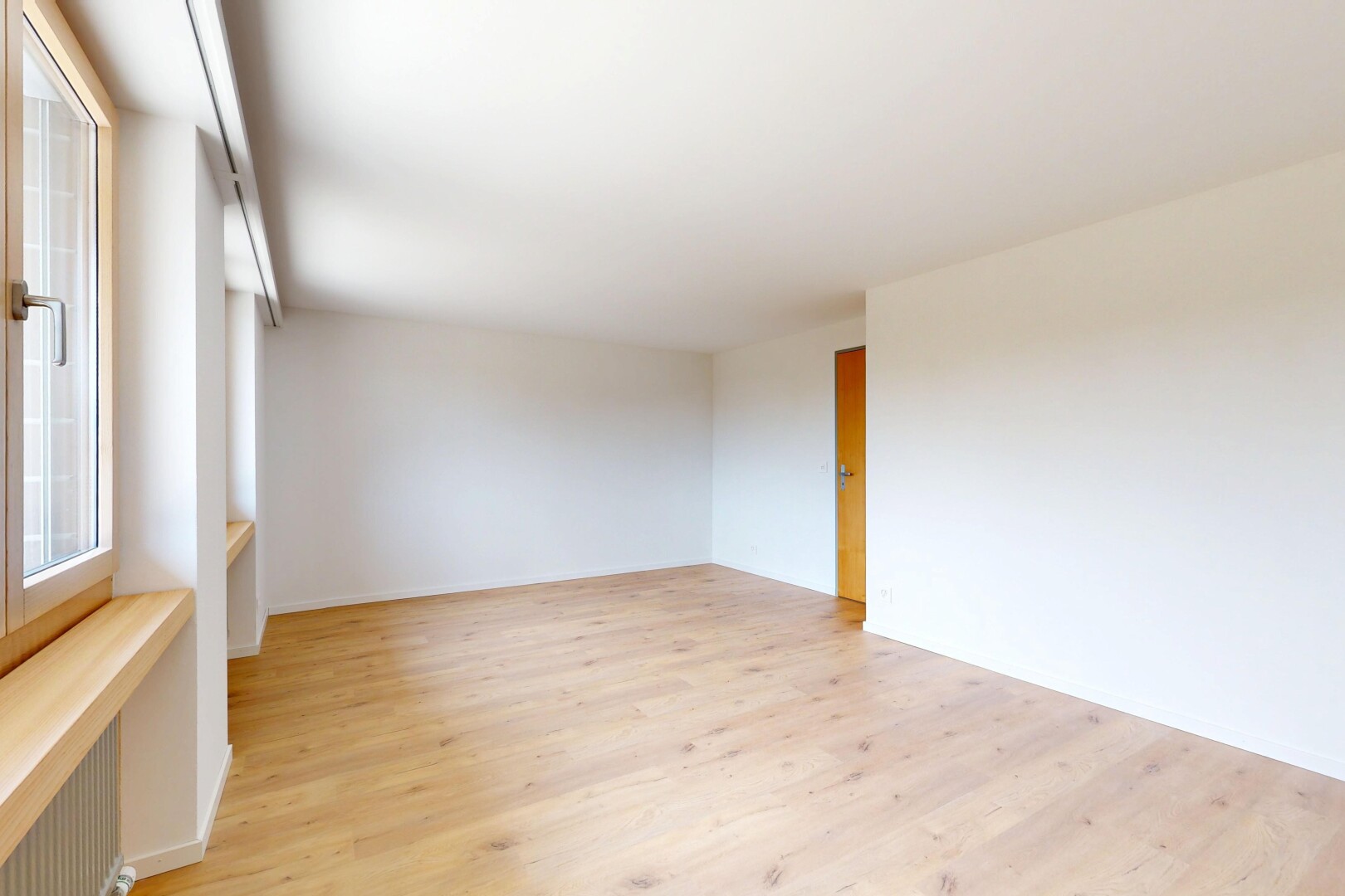 spare room featuring light wood-style flooring and radiator heating unit