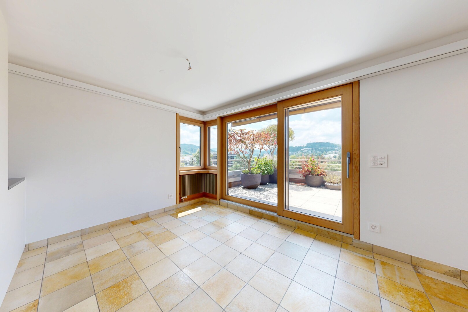 empty room with a mountain view, ornamental molding, and light tile patterned flooring