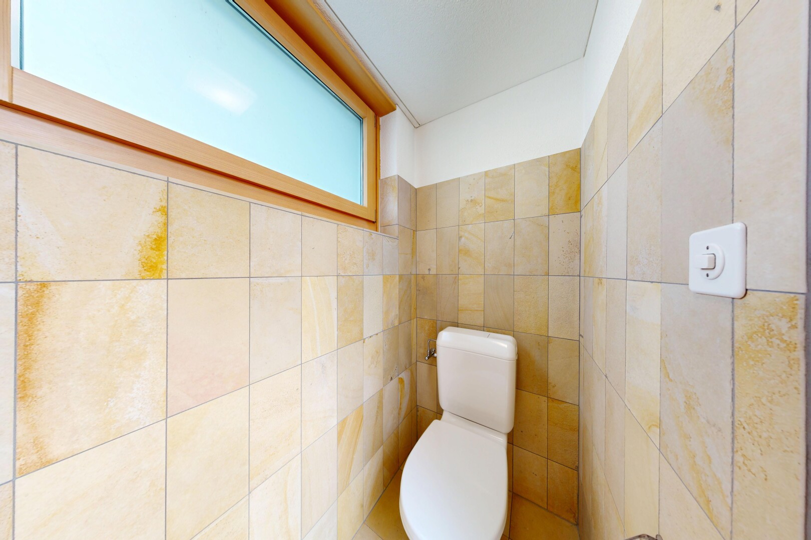 half bathroom with toilet and tile walls