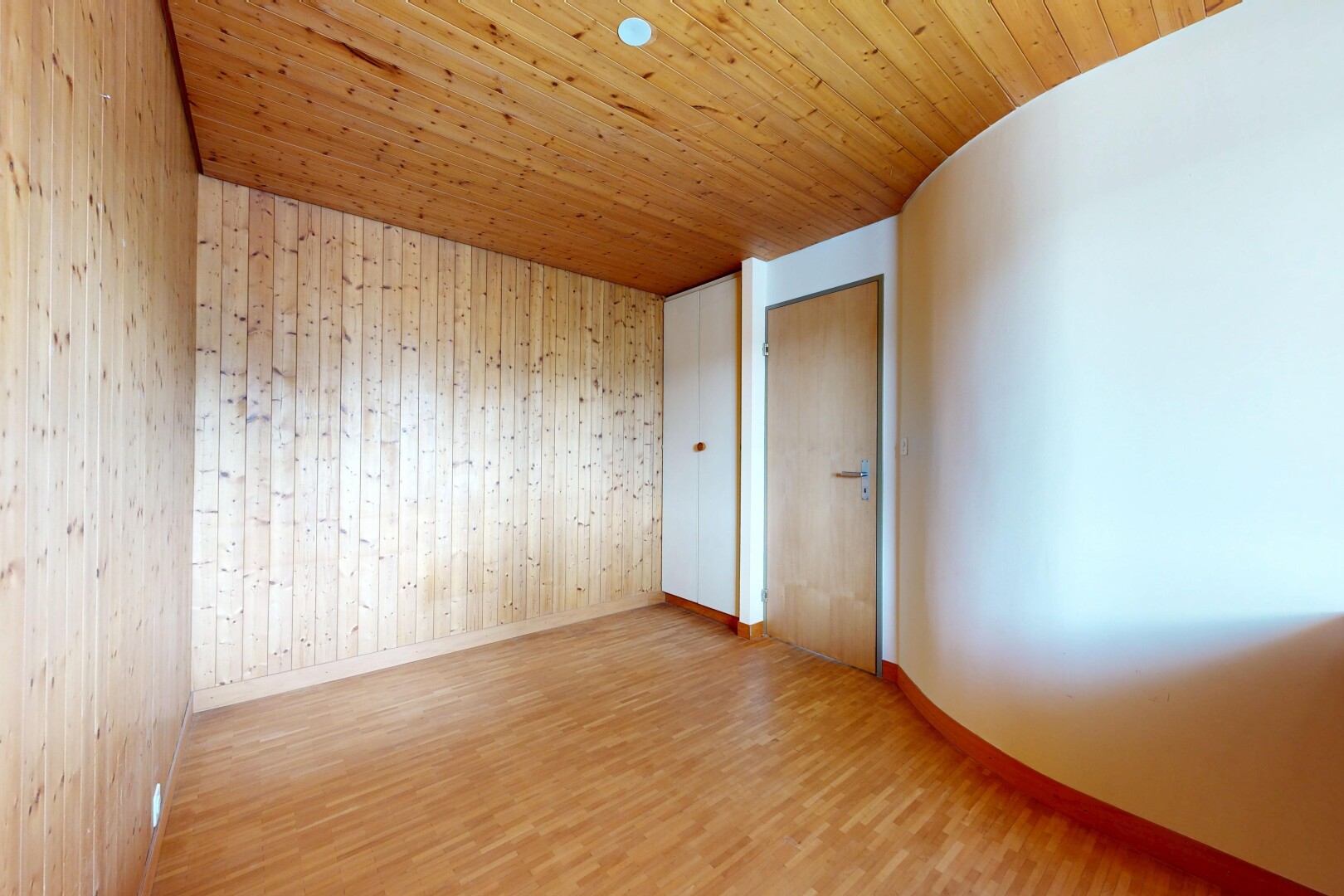 empty room with light wood-style flooring, wood walls, and wood ceiling