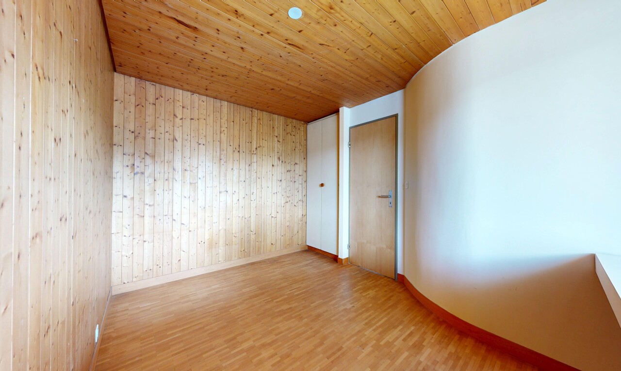 empty room with light wood-style flooring, wood walls, and wood ceiling