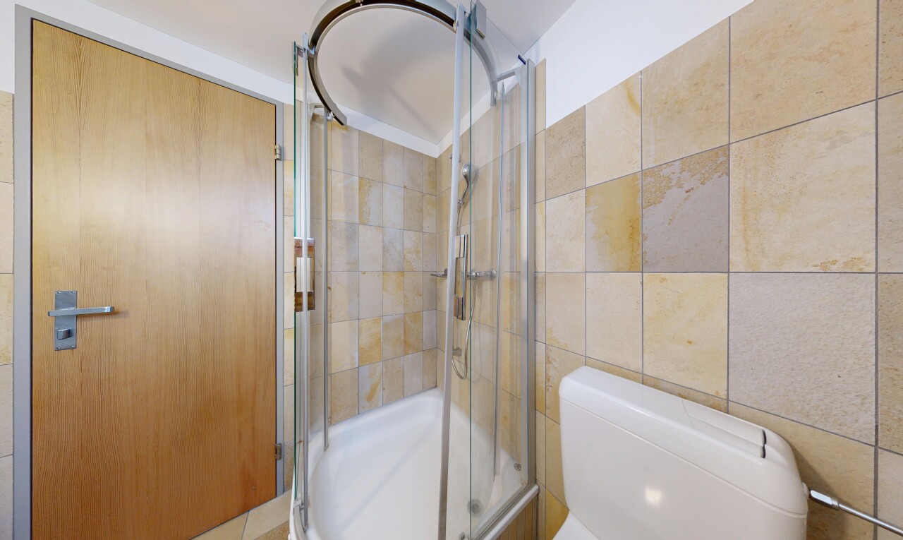 bathroom with a stall shower and toilet