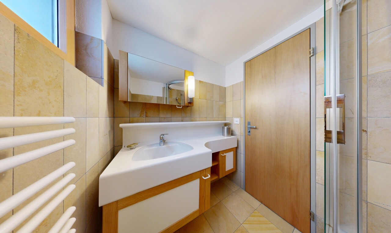 full bathroom with a towel warmer, tile walls, radiator, vanity, and light tile patterned flooring