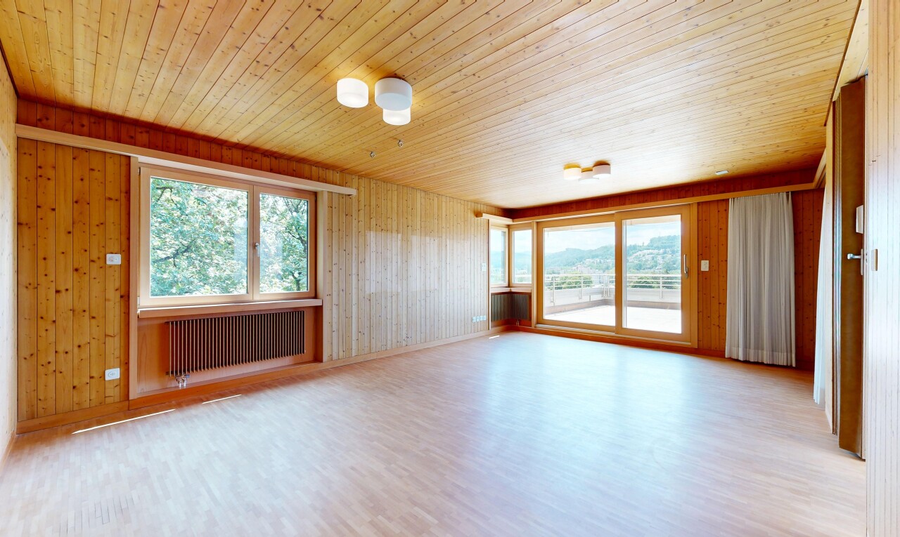 empty room with healthy amount of natural light, light wood-style flooring, radiator, wood walls, and wooden ceiling