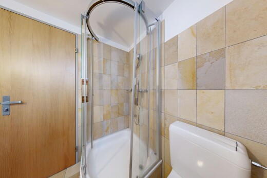 bathroom with a stall shower and toilet