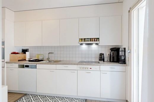 kitchen with decorative backsplash and white cabinets