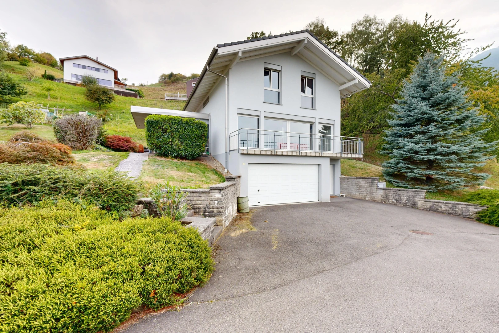 façade avec property visible, garage au sous-sol, allée, overcast, et garage intégré