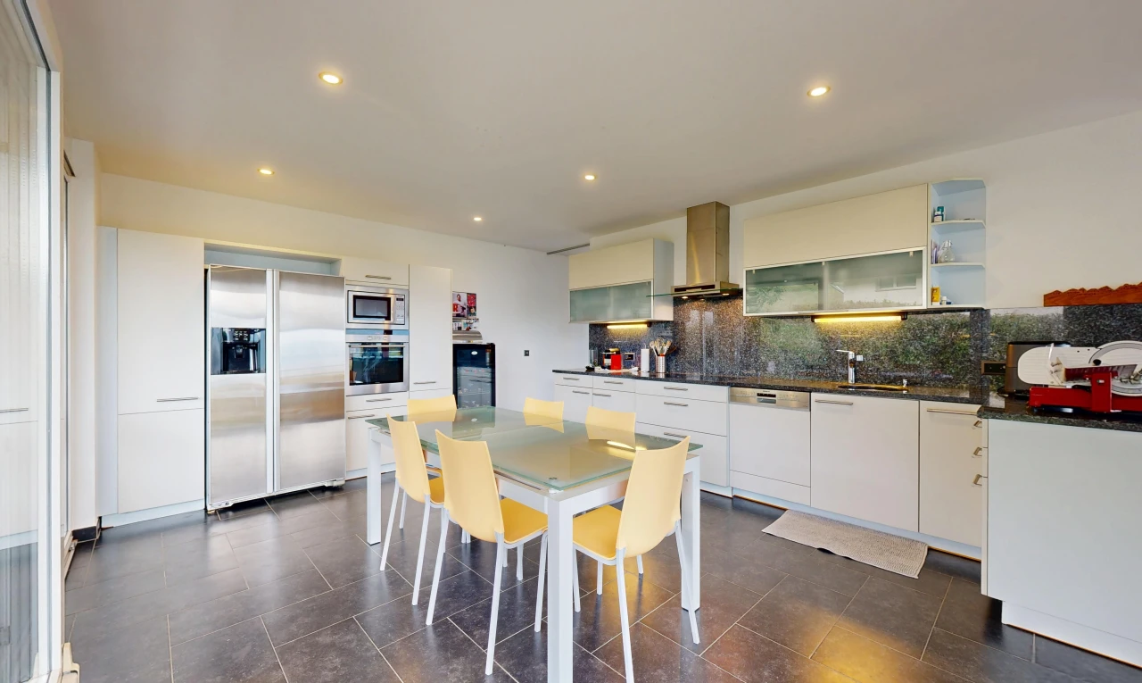 cuisine avec dark floor, réfrigérateur, armoires avec insert en verre, glass insert cabinets, et plans de travail