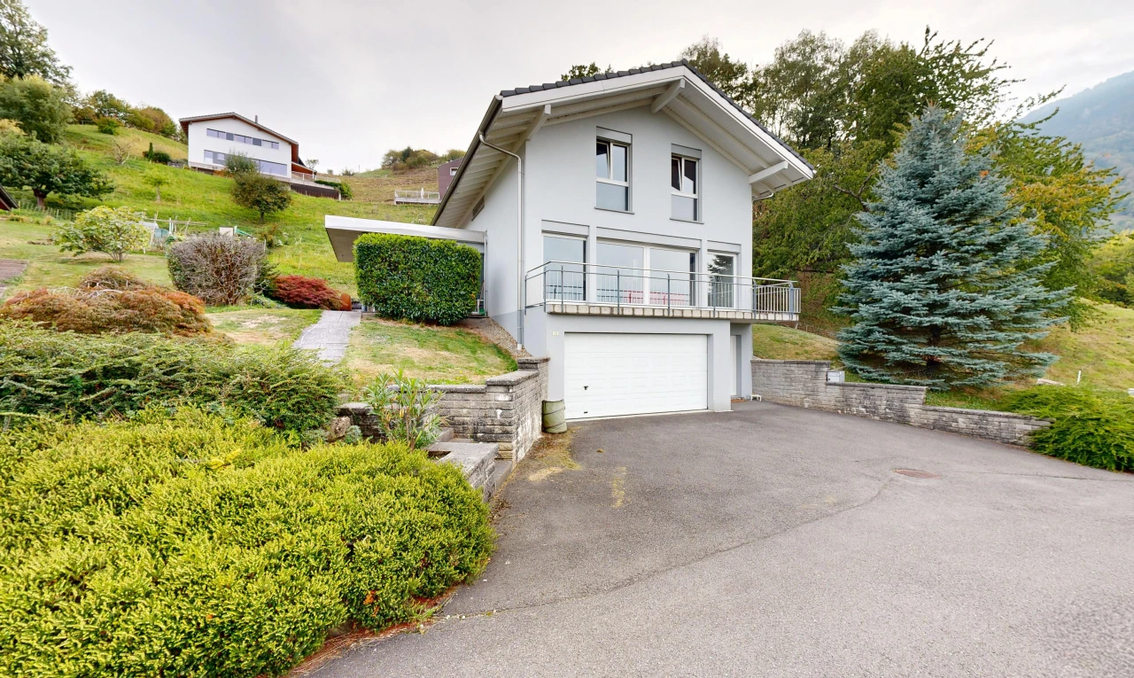 façade avec property visible, garage au sous-sol, allée, overcast, et garage intégré