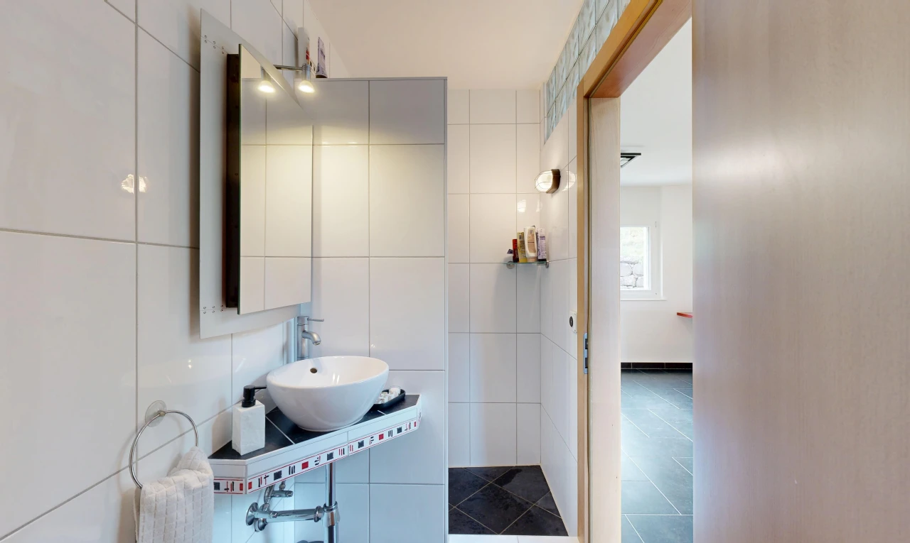 salle de bains avec miroir, évier, mur en carrelage, tile wall, et inside property