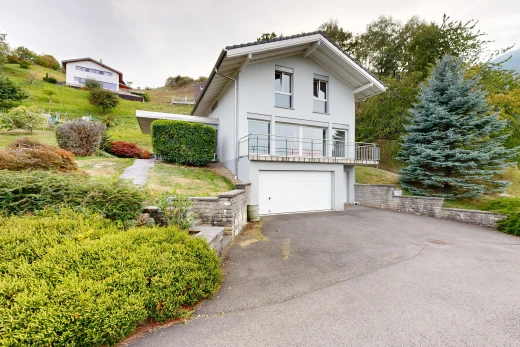 façade avec property visible, garage au sous-sol, allée, overcast, et garage intégré