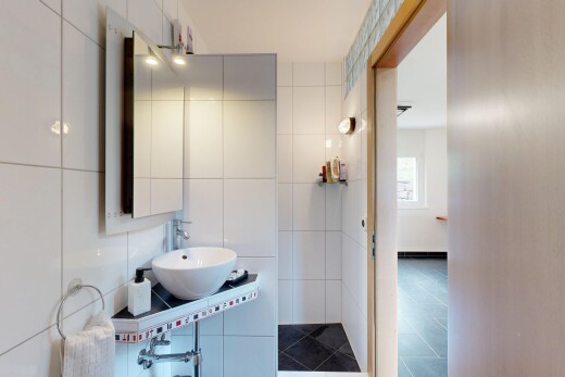 bad mit spiegel, waschbecken, fliesenwand, tile wall, und inside property