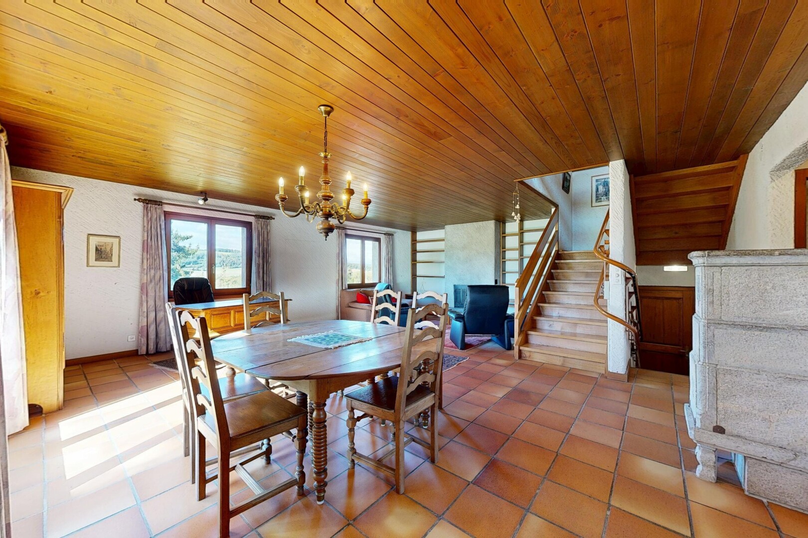 salle à manger avec escaliers, plafond en bois, wood ceiling, lustre remarquable, et lumière naturelle
