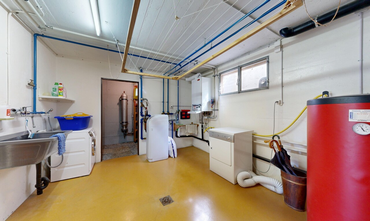 buanderie avec finished concrete floor, chauffe-eau, concrete floor, inside community, et buanderie