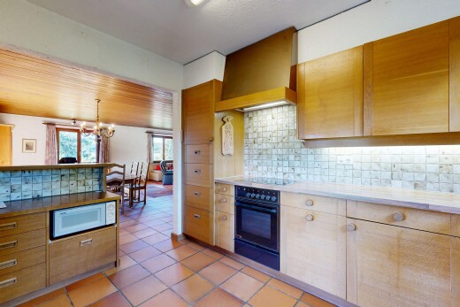 cuisine avec dosseret, backsplash, lustre remarquable, hotte, et lumière naturelle