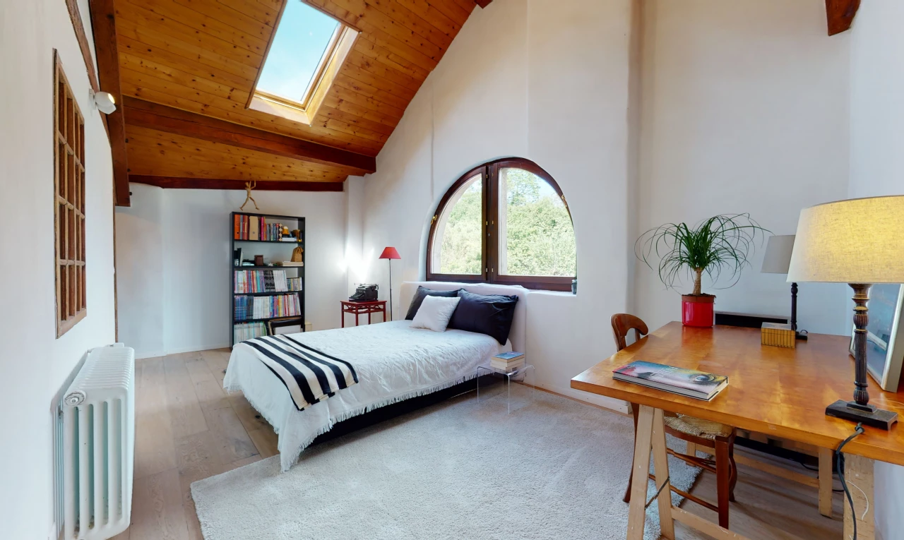 chambre à coucher avec plafond voûté, lumière naturelle, lucarne, et radiateur