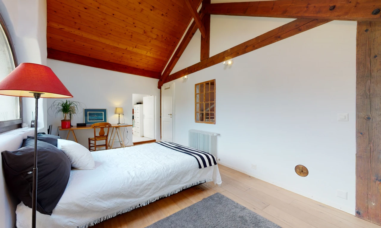 chambre à coucher avec plafond voûté, parquet, et radiateur