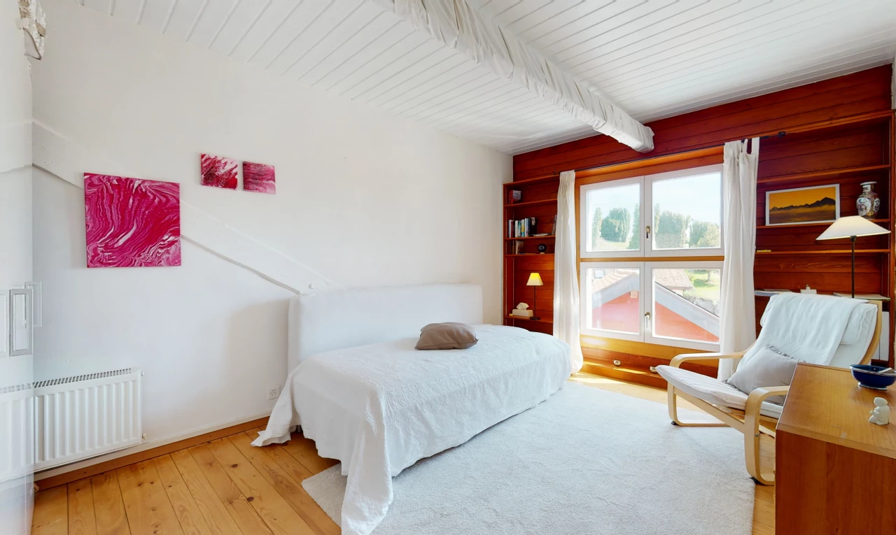 chambre à coucher avec parquet, lumière naturelle, poutres apparentes, et radiateur