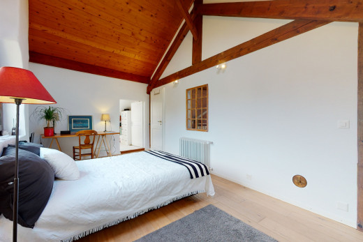 chambre à coucher avec plafond voûté, parquet, et radiateur