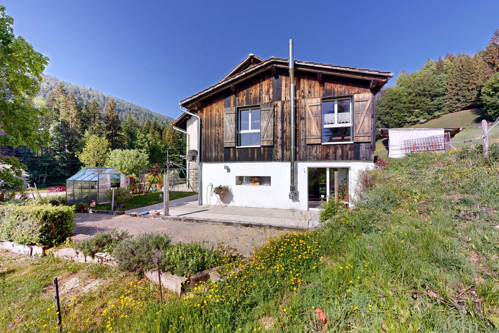 façade avec bardage vertical, bardage en bois, property visible, serre, et day time