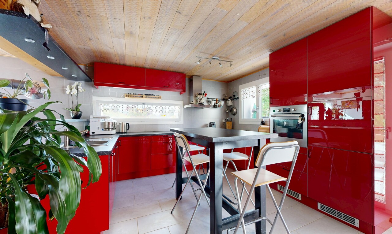 cuisine avec red cabinets, armoires rouges, wood ceiling, plafond en bois, et dark countertops