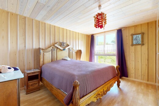 chambre avec sol en finition bois, wood finish floor, plafond en bois, wood ceiling, et lumière naturelle