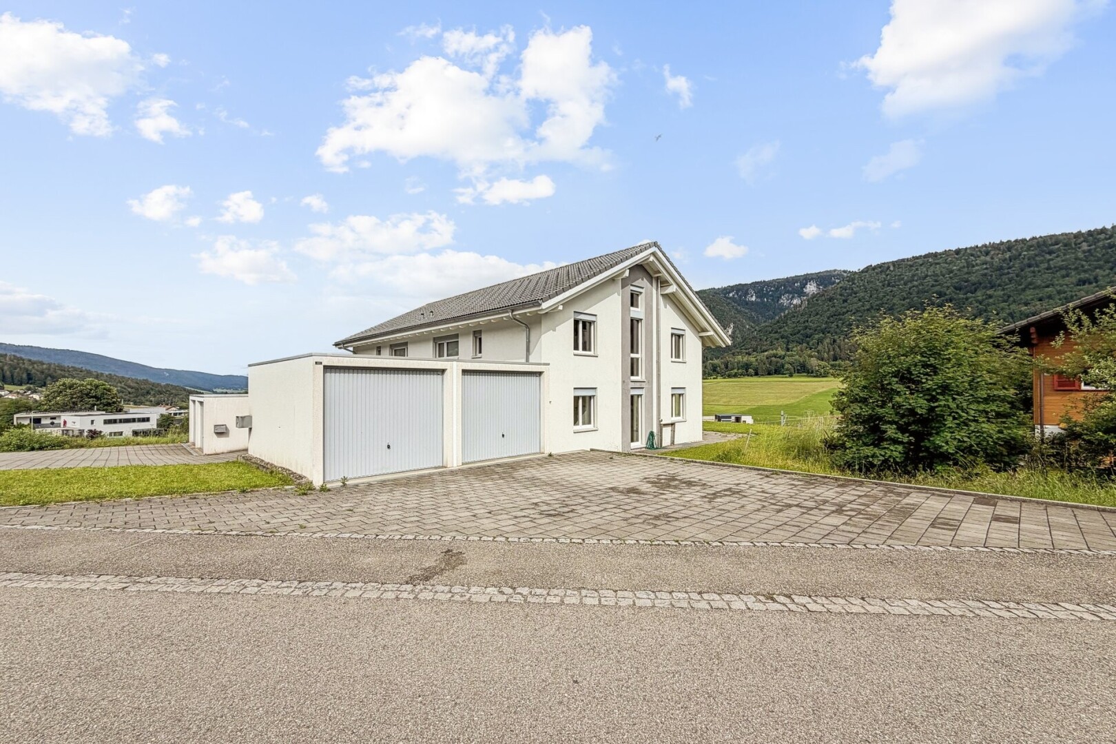 façade avec day time, mountain view, vue sur la montagne, garage, et allée