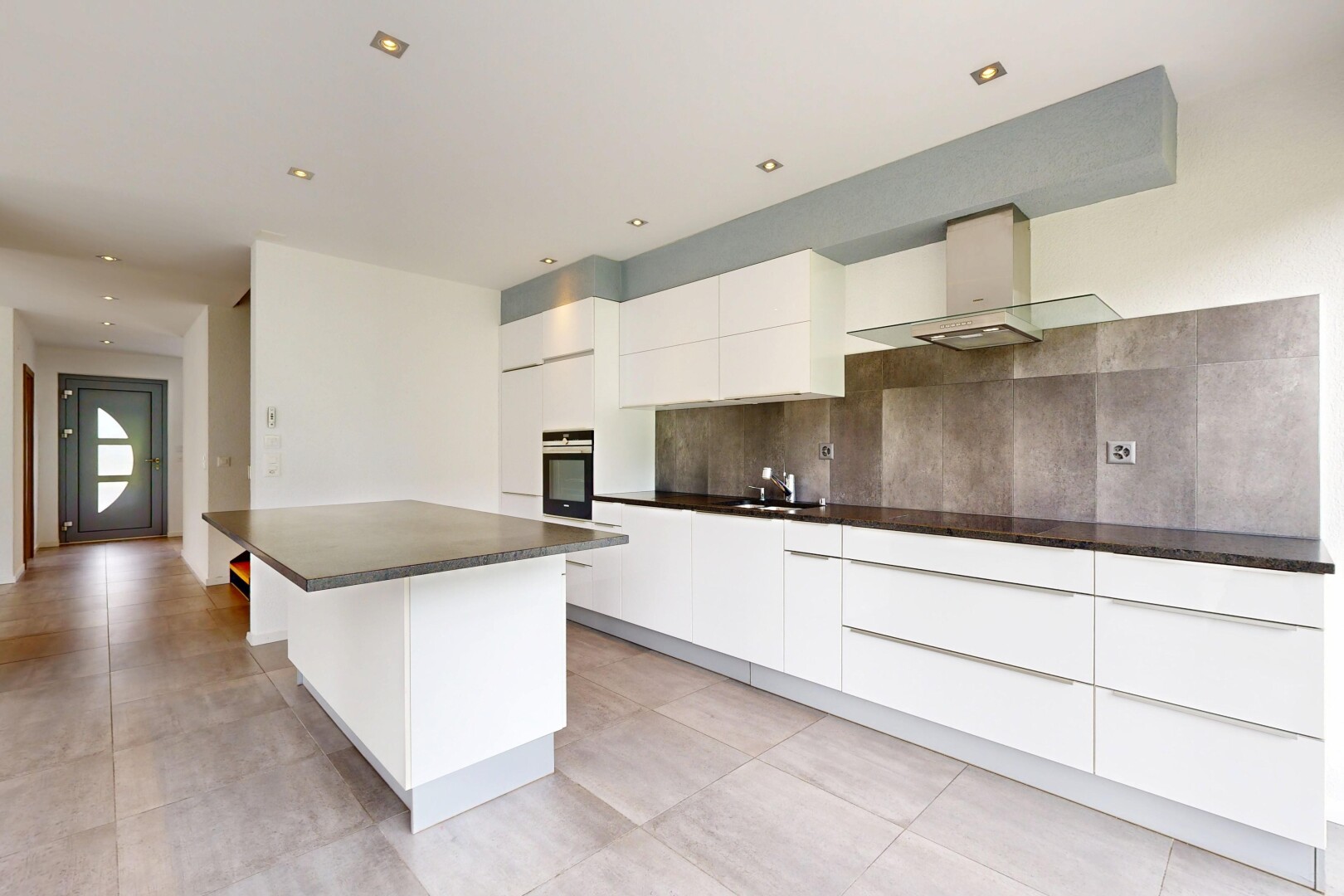 cuisine avec plans de travail, dark countertops, armoires blanches, white cabinets, et armoires à panneau plat