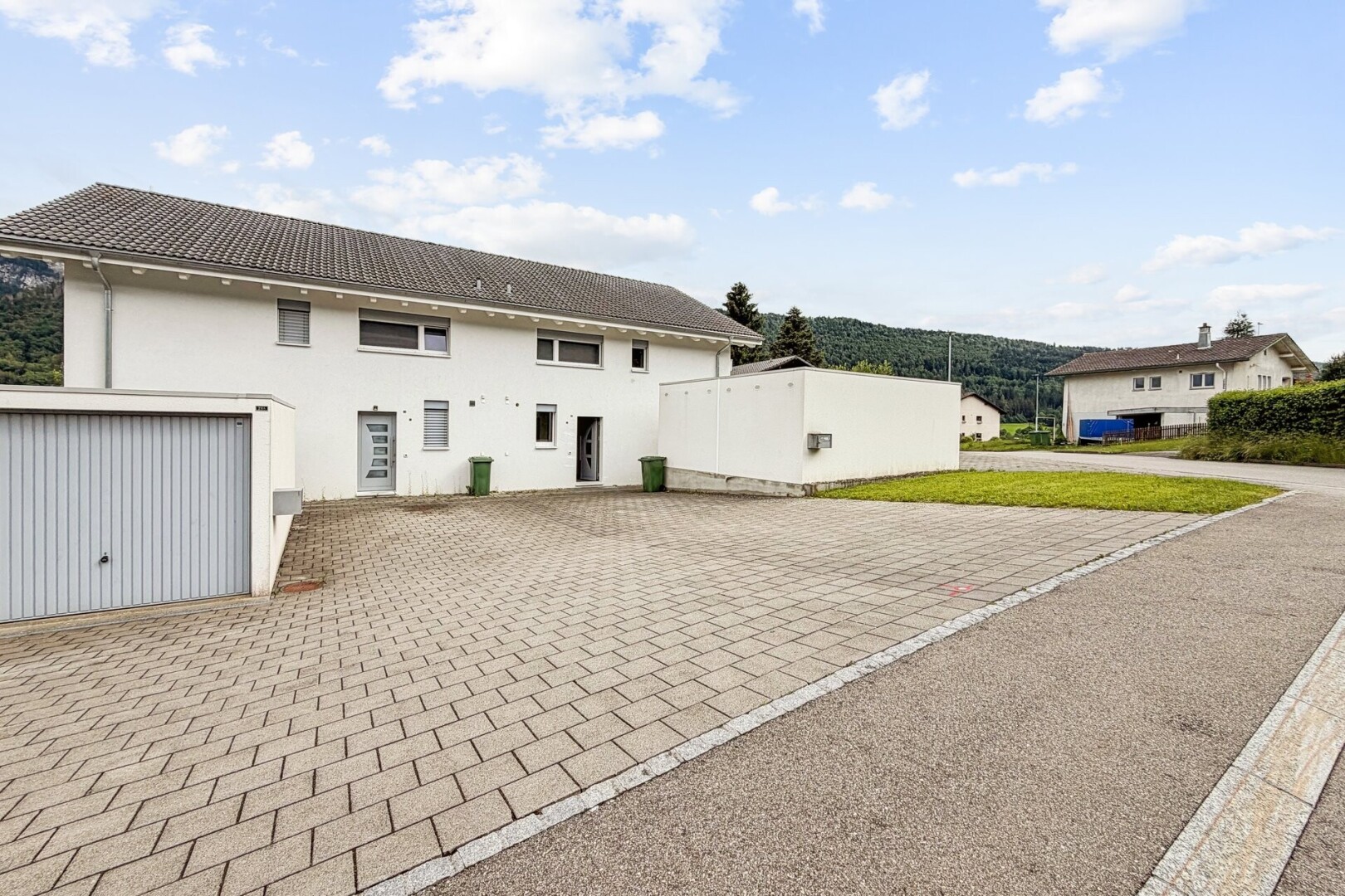 façade avec day time, bardage en stuc, allée, property visible, et garage