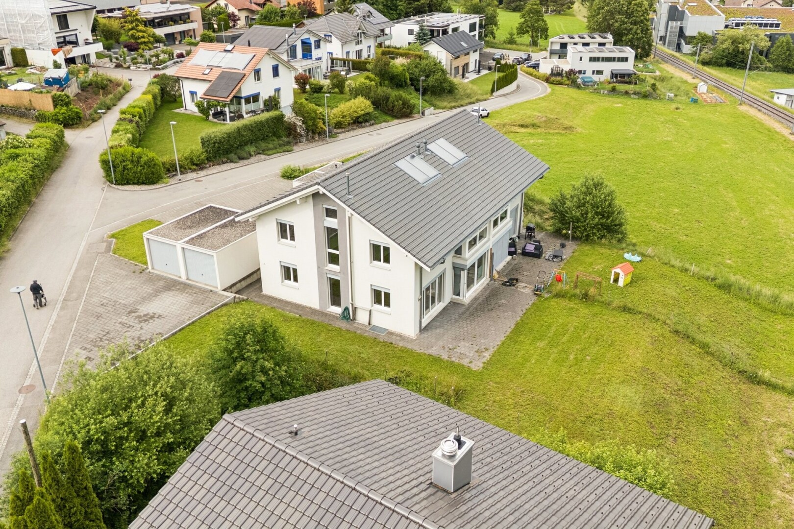 façade avec drone view, residential view, vue résidentielle, pelouse, et garage