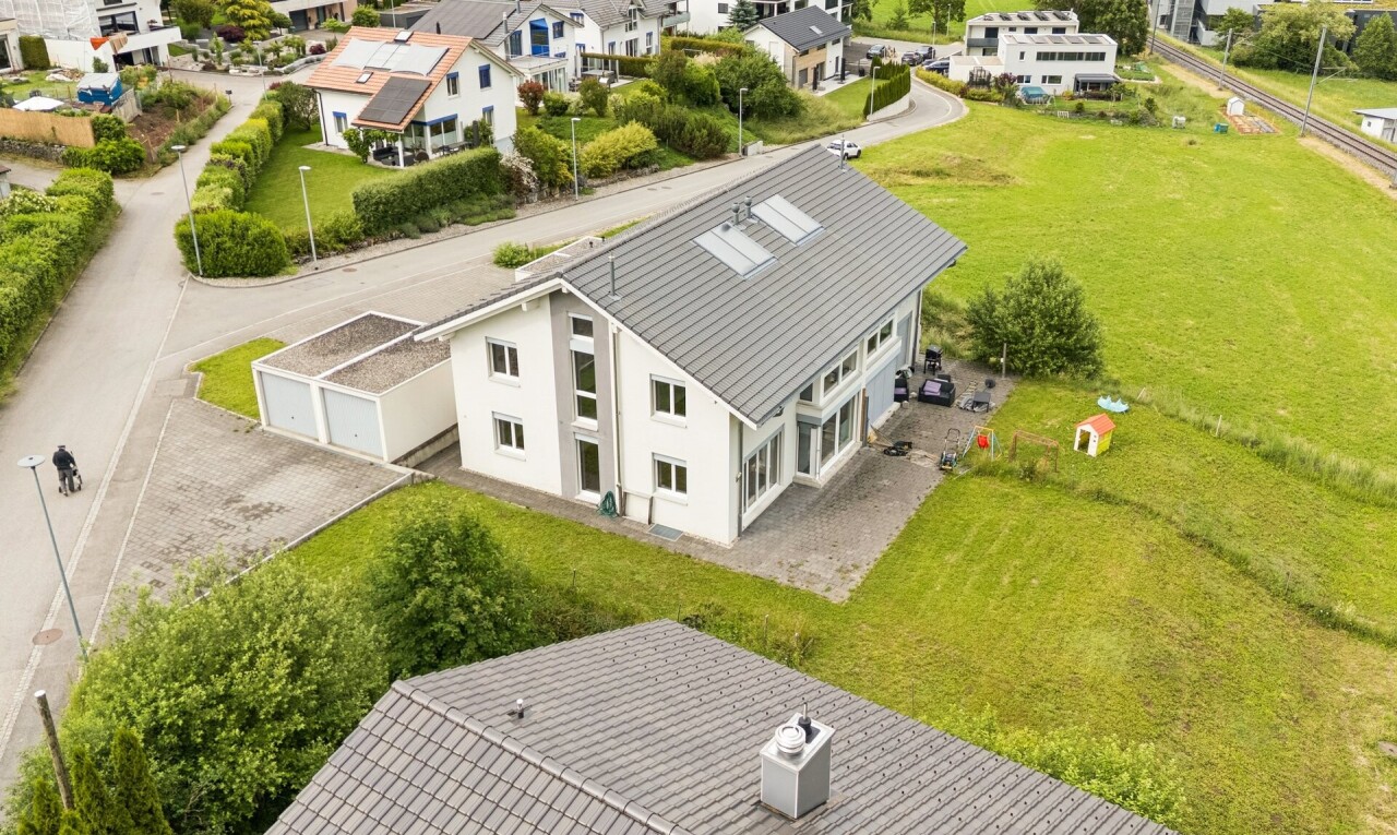 façade avec drone view, residential view, vue résidentielle, pelouse, et garage
