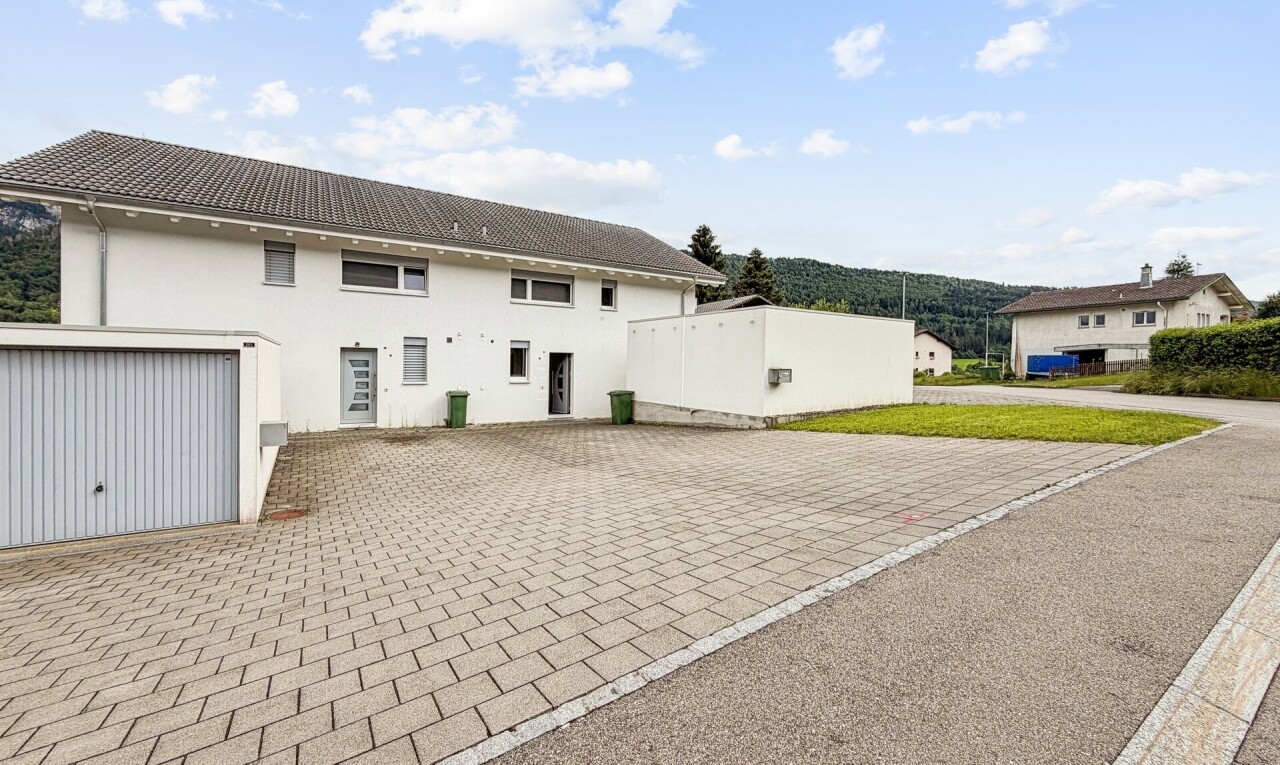façade avec day time, bardage en stuc, allée, property visible, et garage