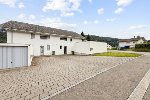 außenansicht mit day time, stuckverkleidung, auffahrt, property visible, und garage