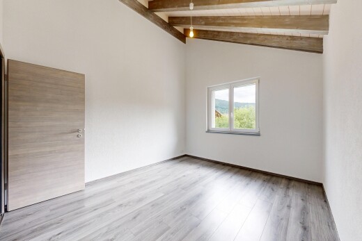 pièce vide avec beamed ceiling, plafond à poutres, inside property, wood finish floor, et sol en finition bois