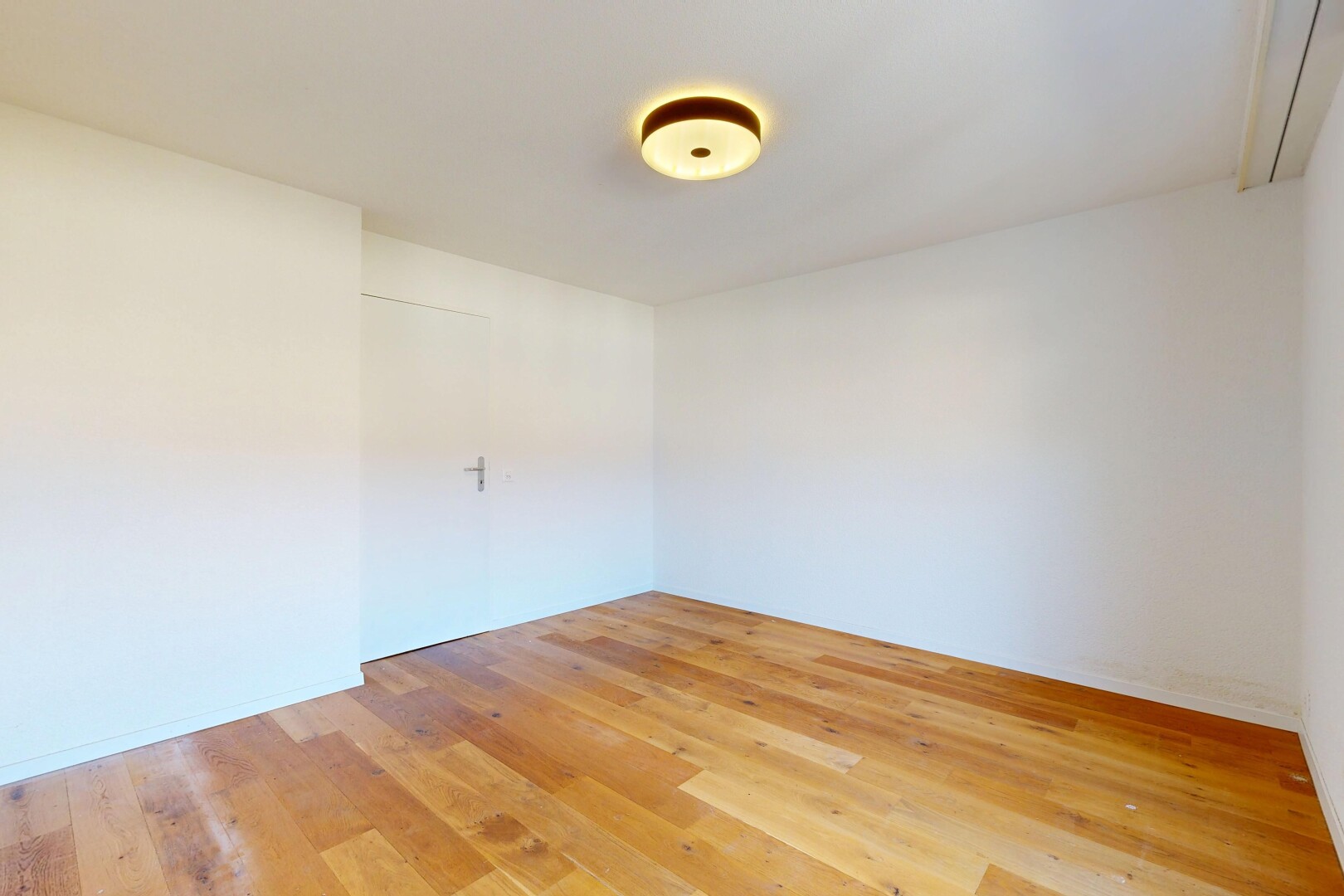 pièce vide avec wood finish floor, sol en finition bois, drywall, cloison sèche, et inside property