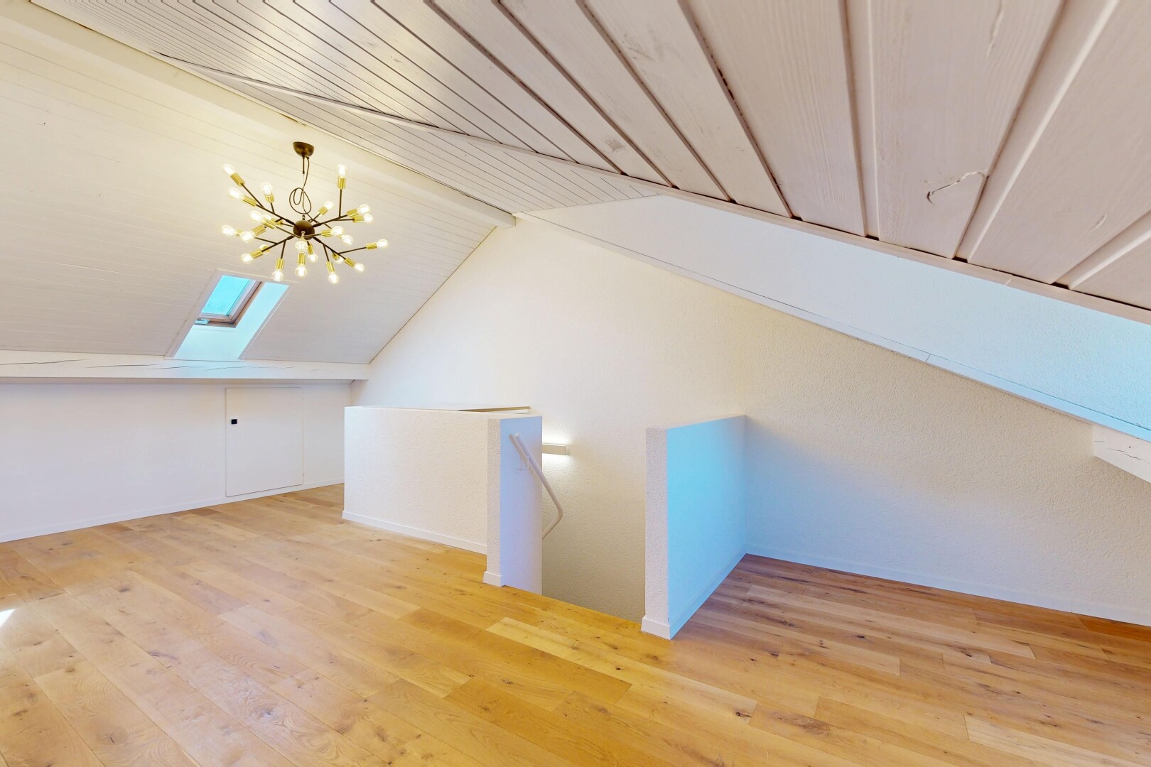 pièce vide avec sol en finition bois, wood finish floor, puits de lumière, lustre remarquable, et plafond bas