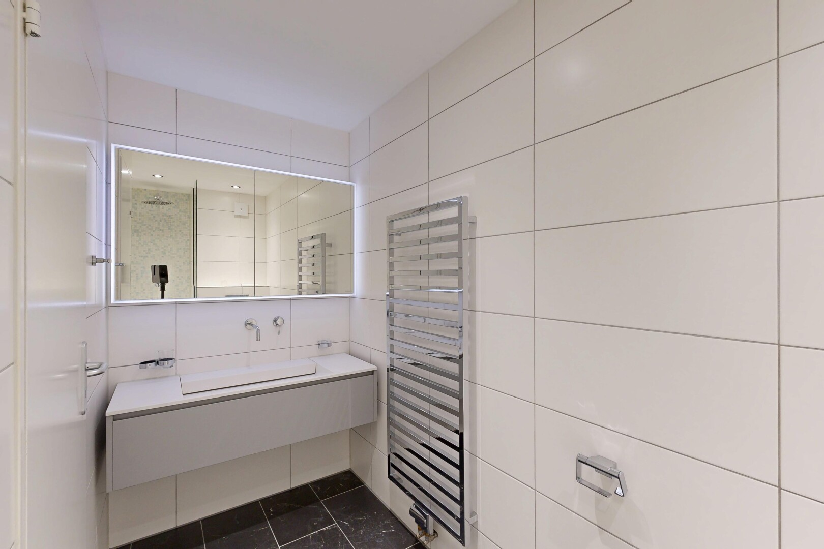 salle de bains avec chauffe-serviettes, radiateur, dark floor, lavabo (ou coiffeuse selon le contexte), et inside property