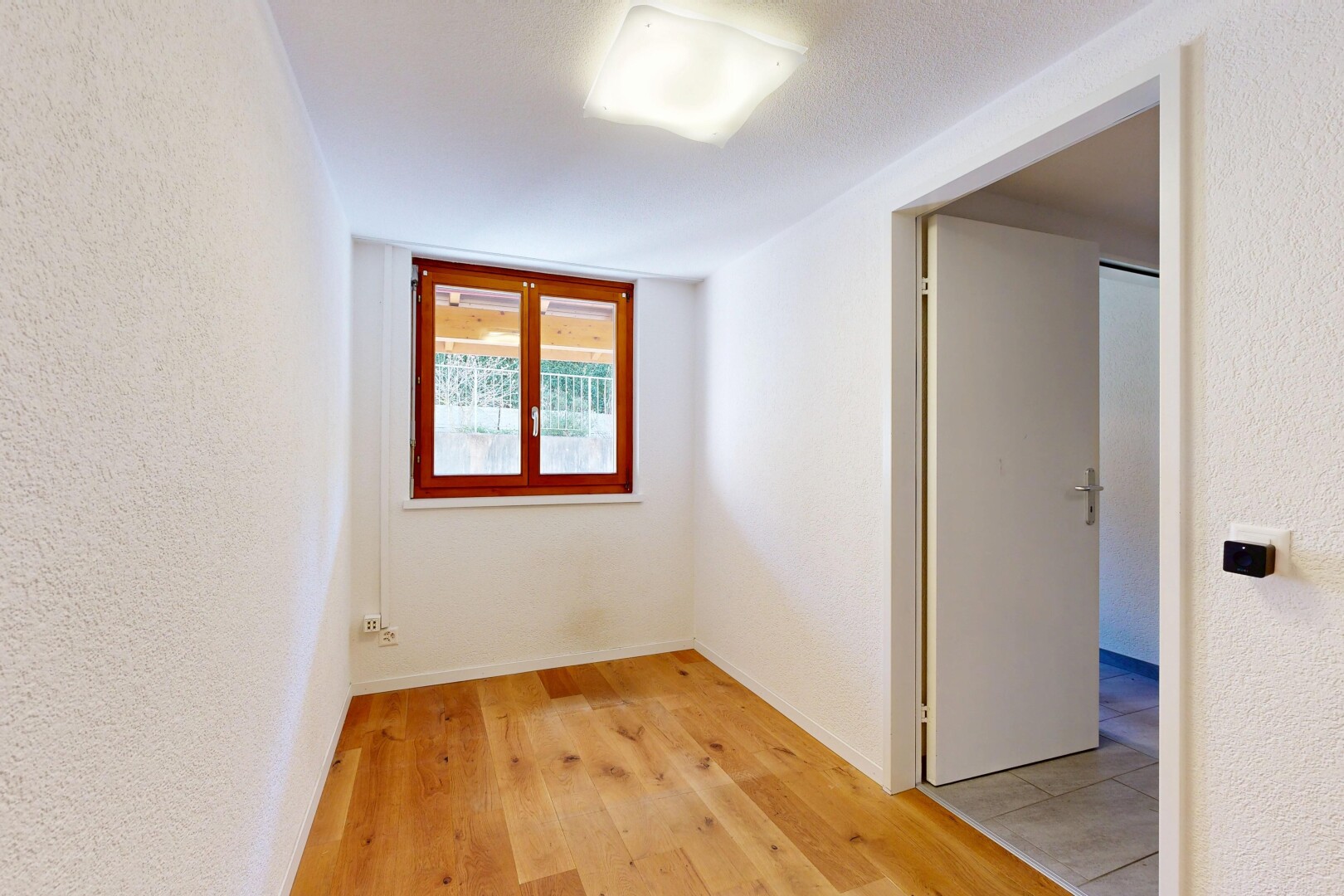 pièce vide avec textured wall, mur texturé, wood finish floor, sol en finition bois, et inside property