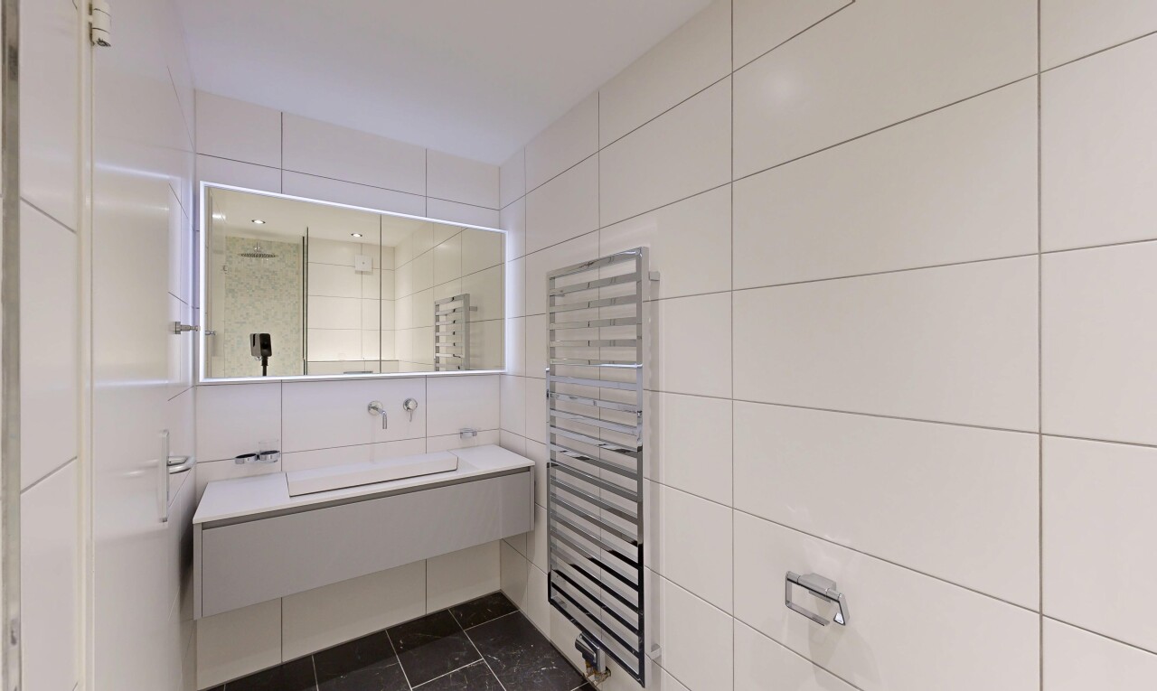 salle de bains avec chauffe-serviettes, radiateur, dark floor, lavabo (ou coiffeuse selon le contexte), et inside property