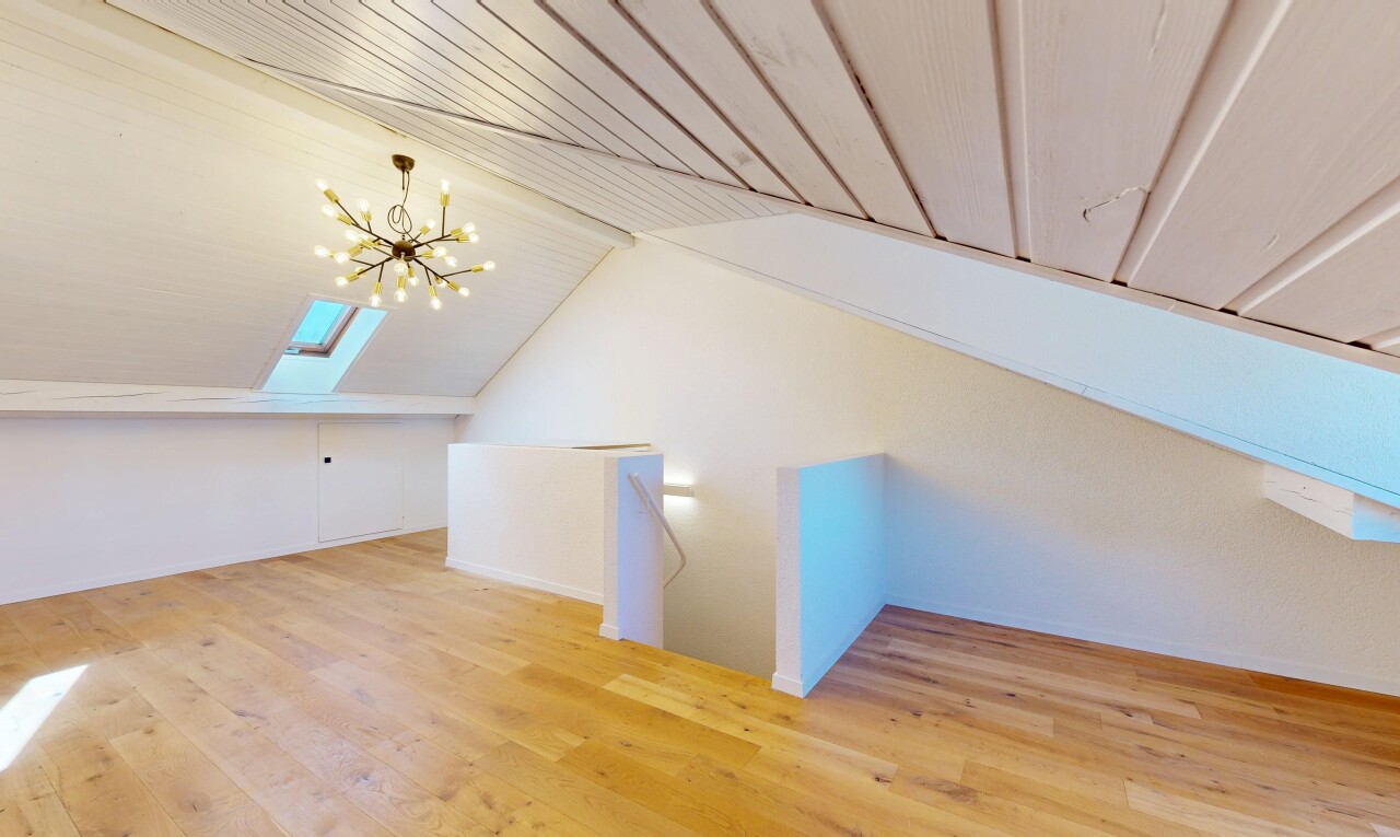 pièce vide avec sol en finition bois, wood finish floor, puits de lumière, lustre remarquable, et plafond bas