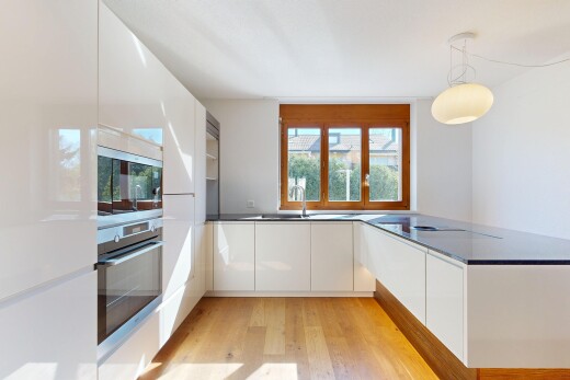 cuisine avec four, armoires à panneau plat, flat panel cabinets, dark countertops, et sol en finition bois