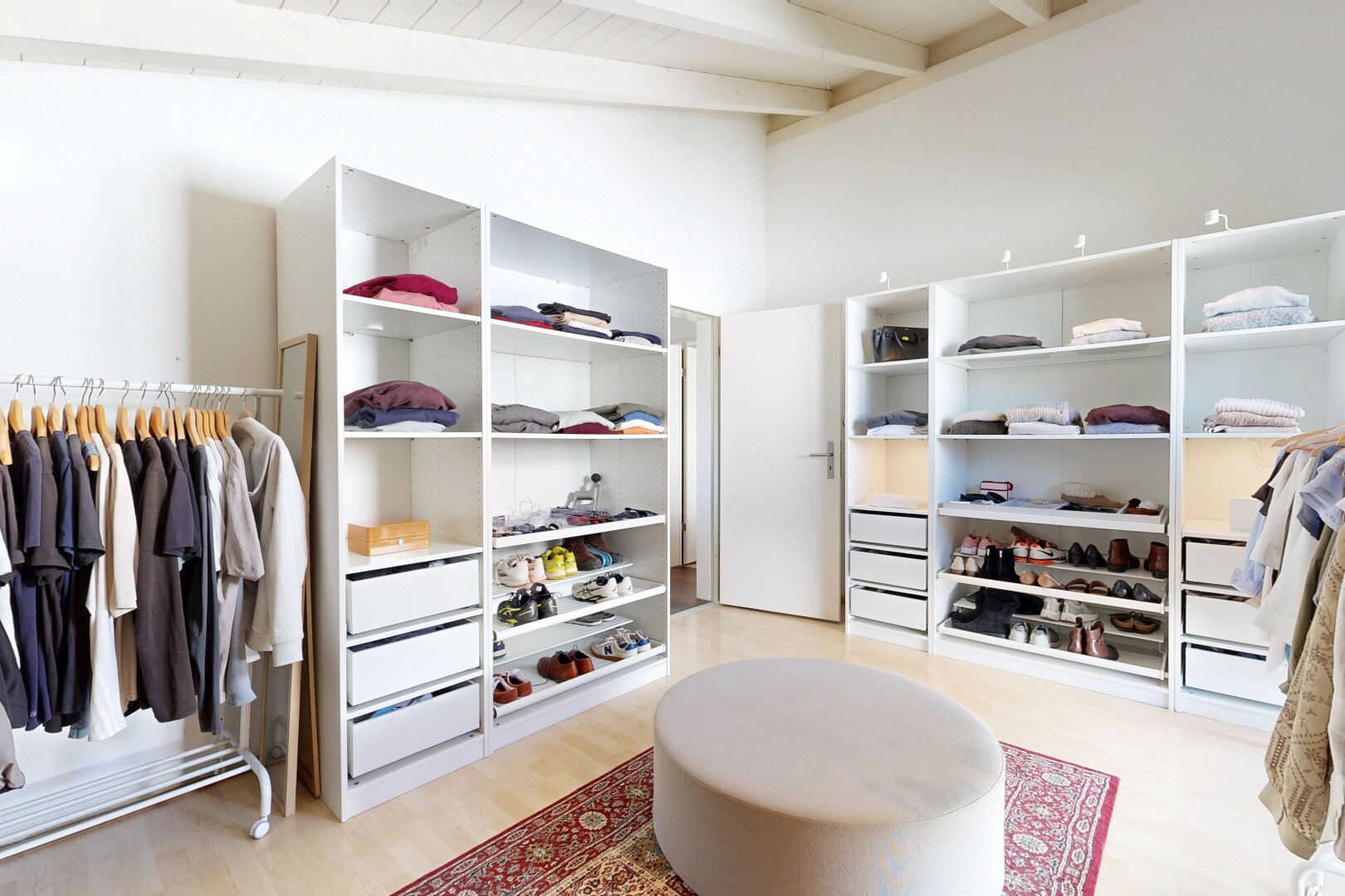 walk in closet with light wood finished floors
