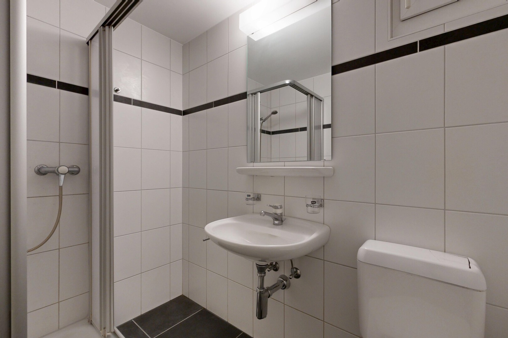 bathroom with a stall shower and tile walls